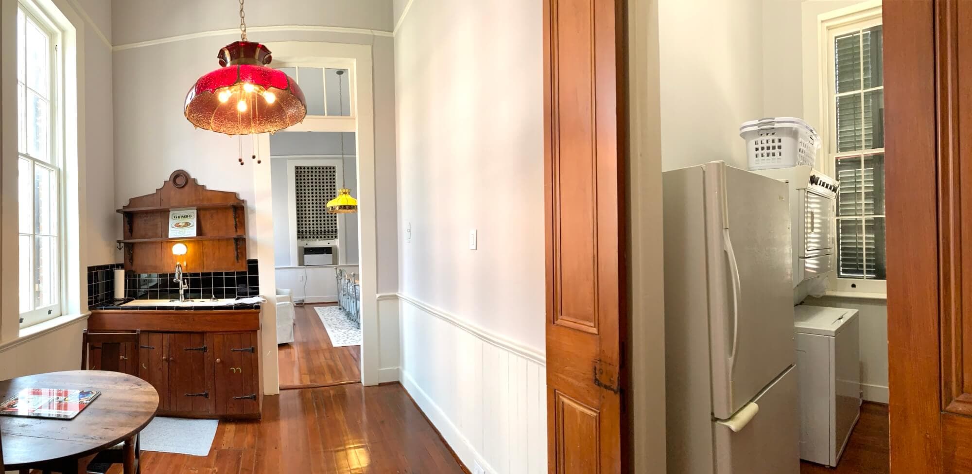 A bright kitchen featuring wooden cabinetry, a refrigerator, and pendant lighting.