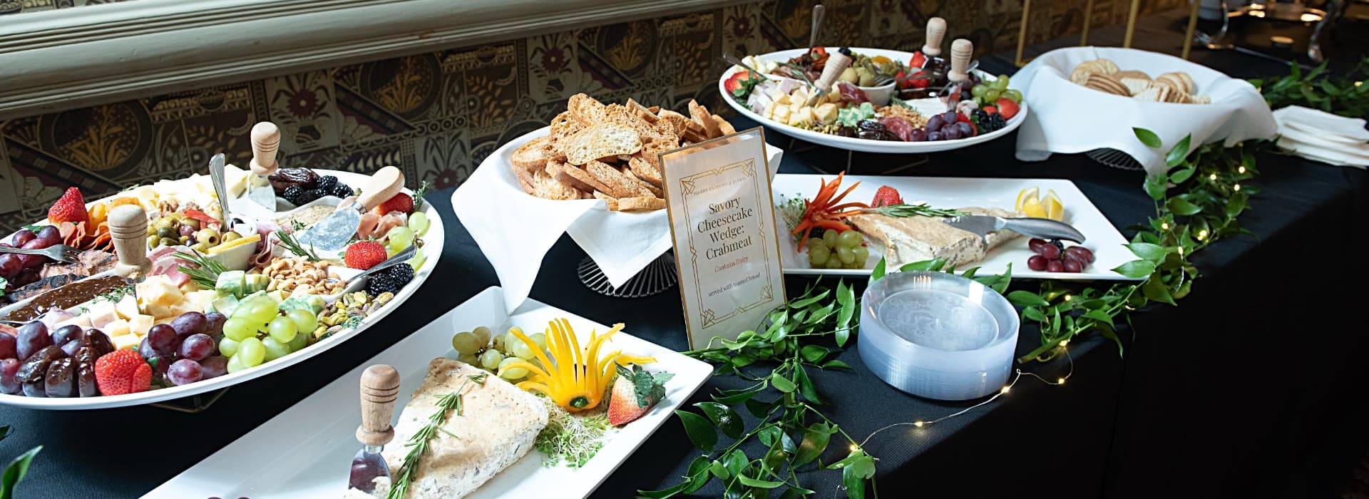 A display of assorted cheeses, fruits, and breads arranged on elegant platters.
