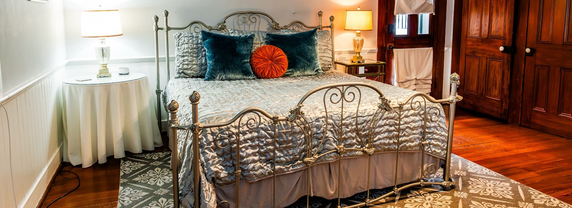 Elegant bedroom featuring a metal bed frame, plush pillows, and a cozy ambiance.