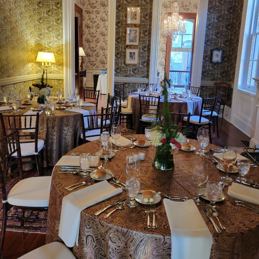 A beautifully set dining room with elegant tables, vintage decor, and floral centerpieces.