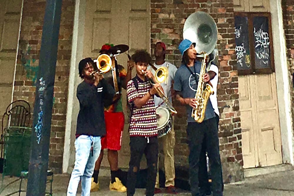 A group of musicians playing brass instruments on a city street.