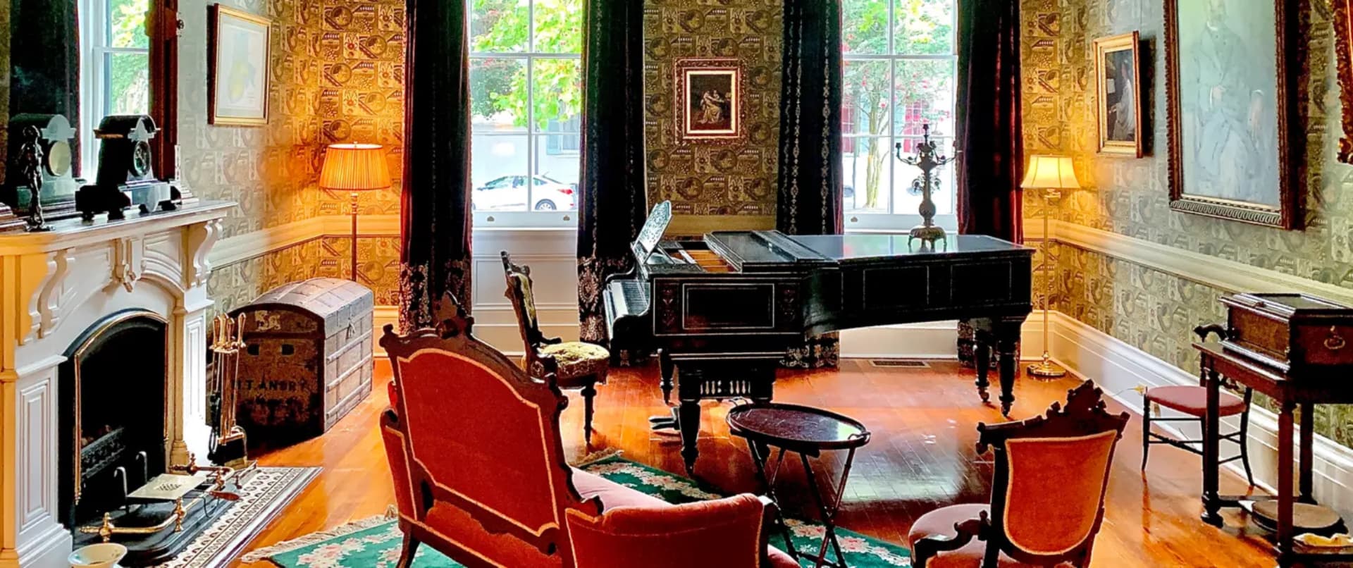 Elegant parlor featuring a grand piano, vintage furniture, and ornate decor.