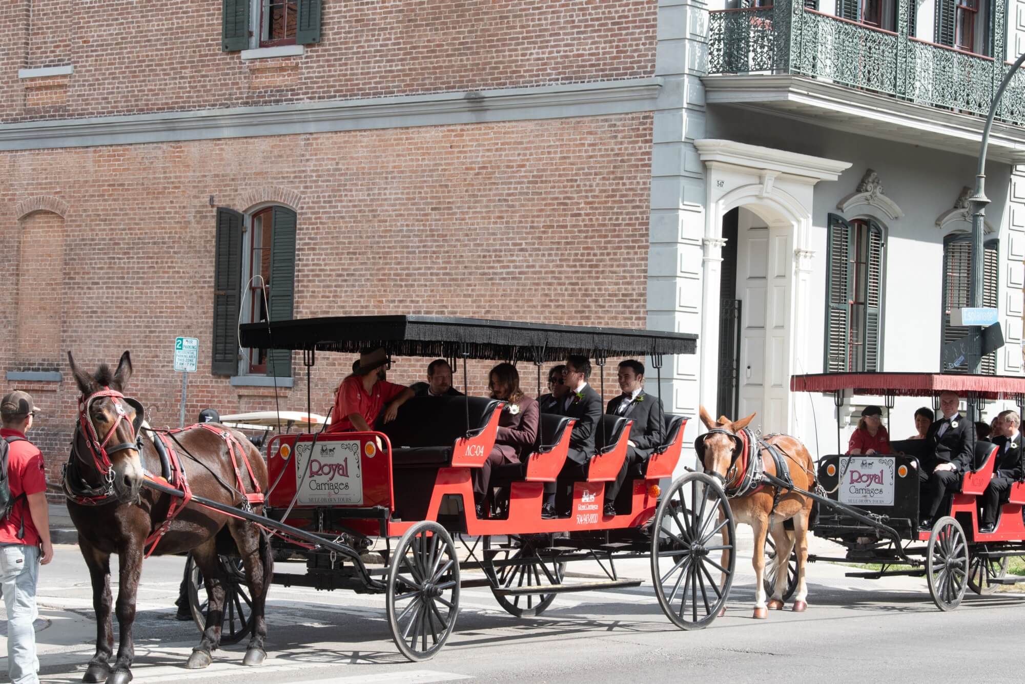 Horse-drawn carriages carrying passengers on a city street.